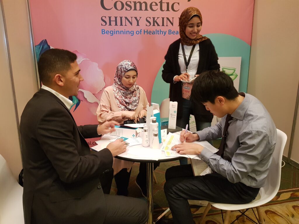 EXCOSMIC repesentative discussing hair care products with international buyers in Cairo, Egypt.